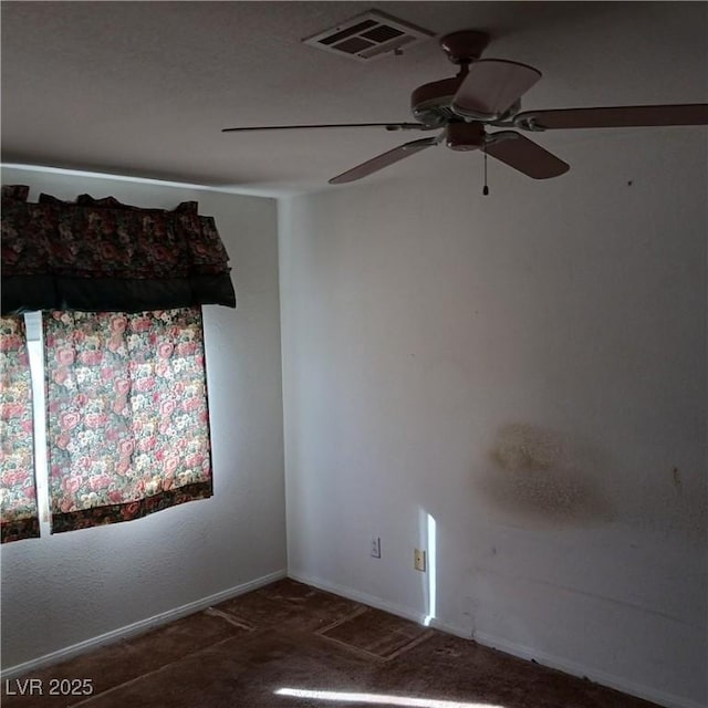 empty room with carpet flooring, baseboards, visible vents, and ceiling fan