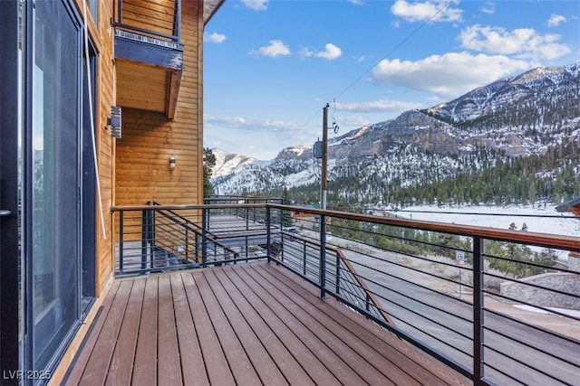 snow covered back of property with a mountain view