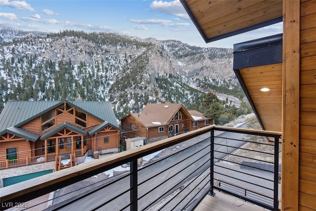 snow covered back of property with a mountain view