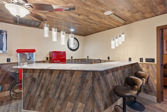 bar with a wainscoted wall, wood ceiling, wet bar, and wood finished floors