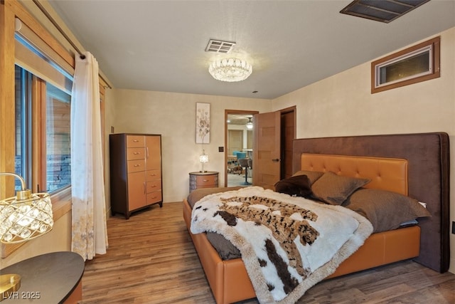 bedroom with wood finished floors and visible vents