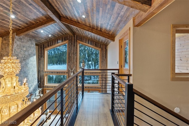 hall featuring wood finished floors, an upstairs landing, lofted ceiling with beams, and wooden ceiling