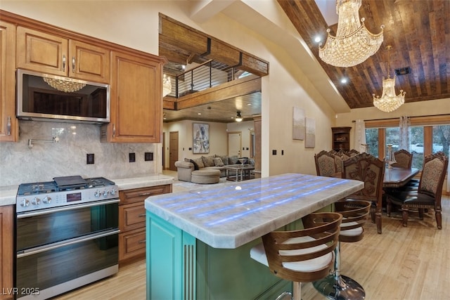 kitchen featuring open floor plan, light wood-style flooring, appliances with stainless steel finishes, and light countertops