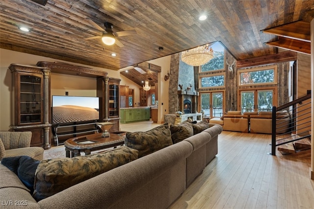 living area with stairway, high vaulted ceiling, ceiling fan, wood ceiling, and wood-type flooring