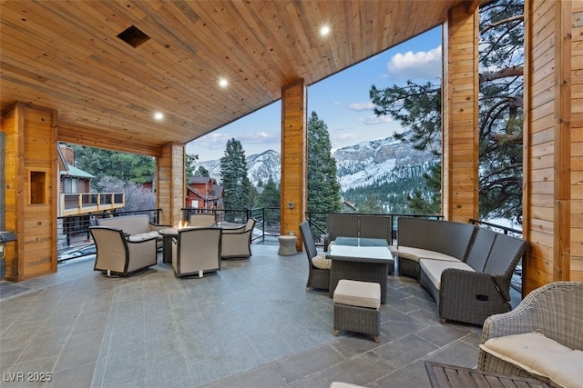 view of patio / terrace with outdoor dining space, a mountain view, and an outdoor hangout area