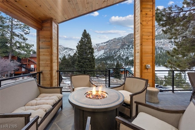 balcony with a mountain view and an outdoor living space with a fire pit