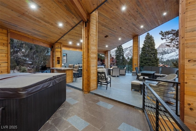 view of patio / terrace featuring outdoor dining space, an outdoor living space, a mountain view, and a hot tub