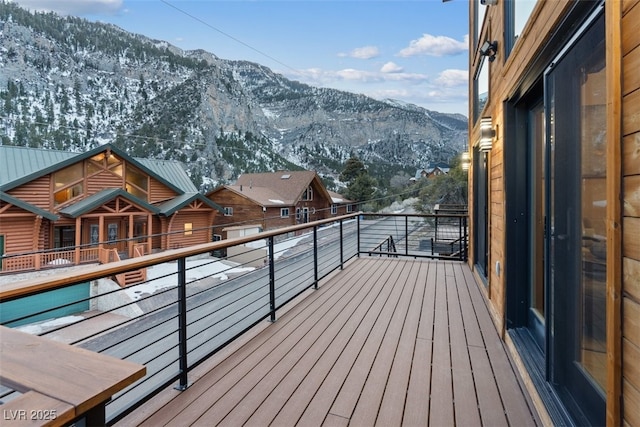 snow covered deck with a mountain view