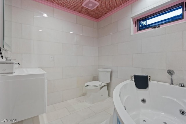 bathroom featuring vanity, crown molding, a jetted tub, toilet, and tile walls