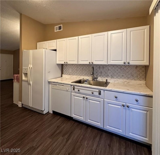 kitchen with white appliances, visible vents, dark wood-style flooring, a sink, and vaulted ceiling