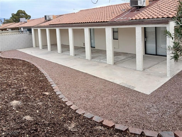 rear view of house featuring stucco siding, central air condition unit, a tile roof, fence, and a patio area