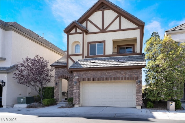 tudor-style house featuring concrete driveway, stucco siding, central AC unit, a garage, and stone siding