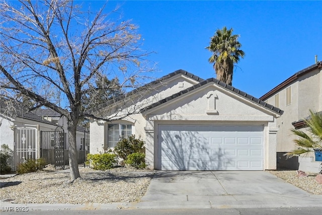 view of front of house with stucco siding, a tiled roof, concrete driveway, and a garage