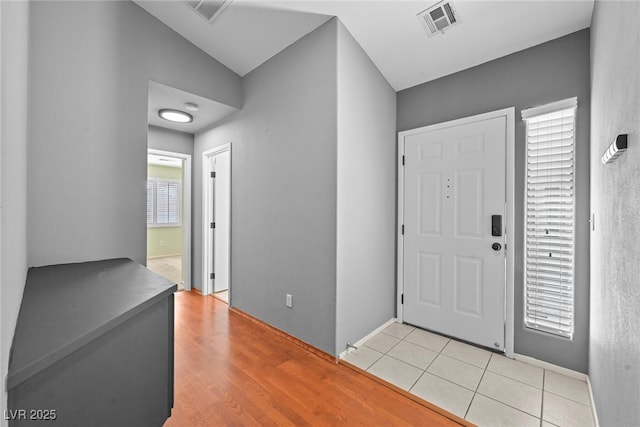 foyer with light tile patterned floors, visible vents, and plenty of natural light