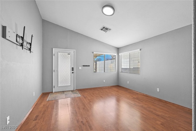 entryway featuring lofted ceiling, wood finished floors, and visible vents