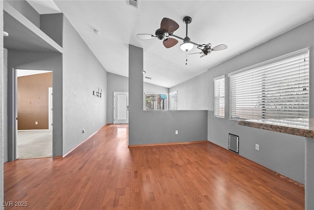 spare room featuring lofted ceiling, wood finished floors, and ceiling fan