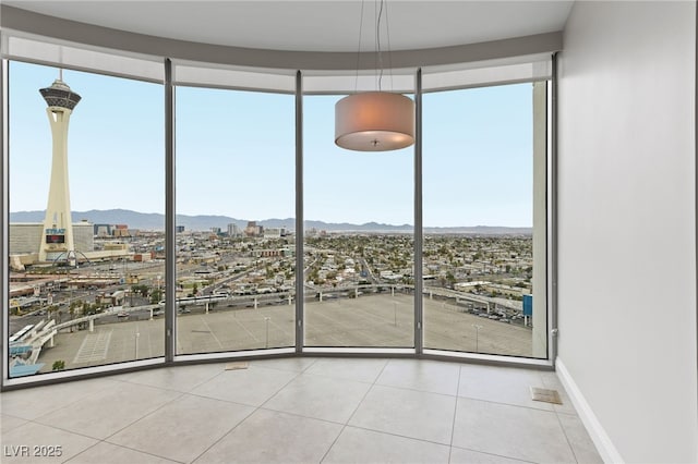 interior space with a city view, a mountain view, and baseboards