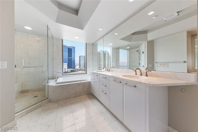 full bath with a garden tub, double vanity, a stall shower, and a sink