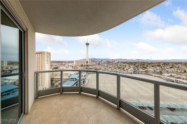 balcony with a mountain view, a city view, and a sunroom