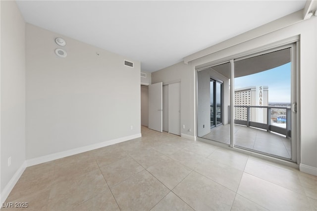 unfurnished room with light tile patterned floors, baseboards, and visible vents