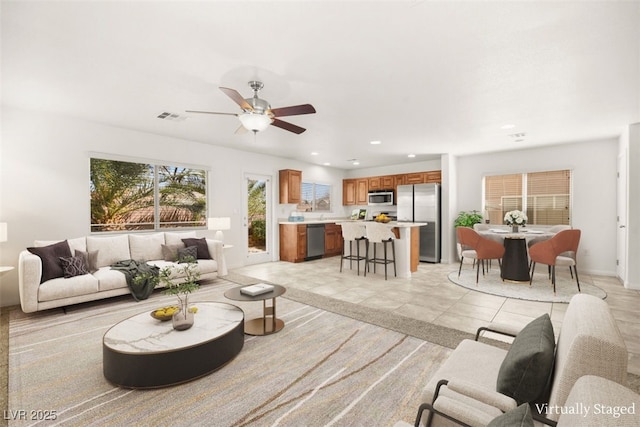 living area with light tile patterned floors, visible vents, recessed lighting, and a ceiling fan