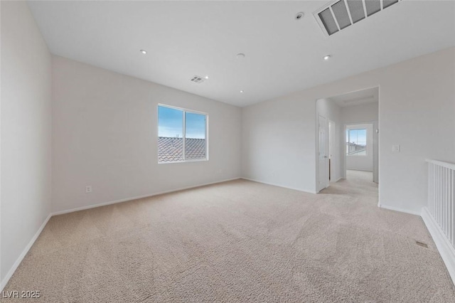 unfurnished room featuring light carpet, visible vents, and baseboards