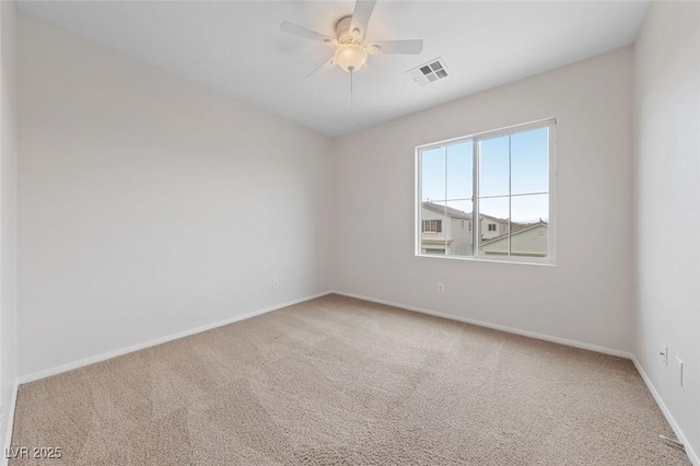 empty room with visible vents, baseboards, carpet, and a ceiling fan