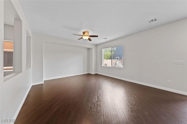 unfurnished room with visible vents, baseboards, ceiling fan, and dark wood-style flooring