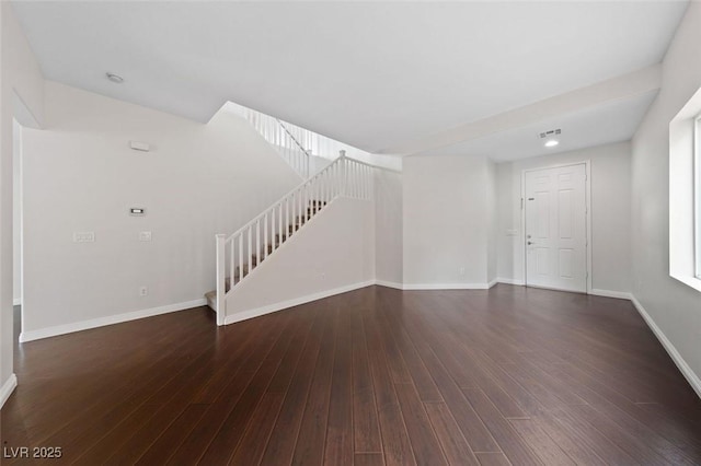 unfurnished living room featuring stairs, visible vents, wood finished floors, and baseboards