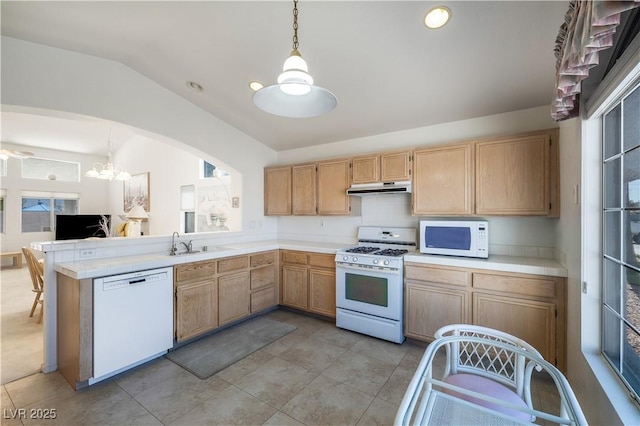 kitchen featuring under cabinet range hood, light brown cabinetry, lofted ceiling, white appliances, and a sink