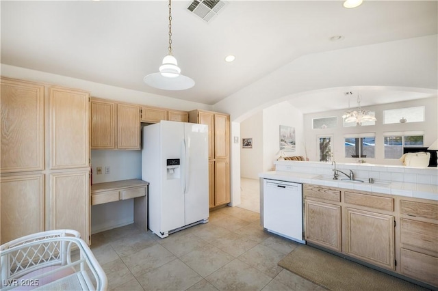 kitchen featuring light brown cabinets, white appliances, lofted ceiling, and arched walkways