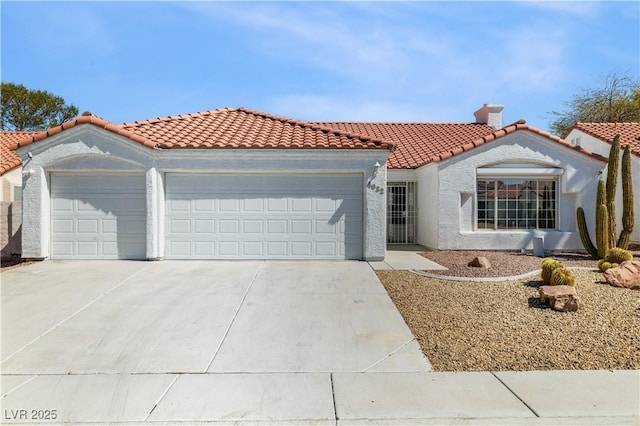 mediterranean / spanish-style house featuring stucco siding, a tiled roof, concrete driveway, and a garage