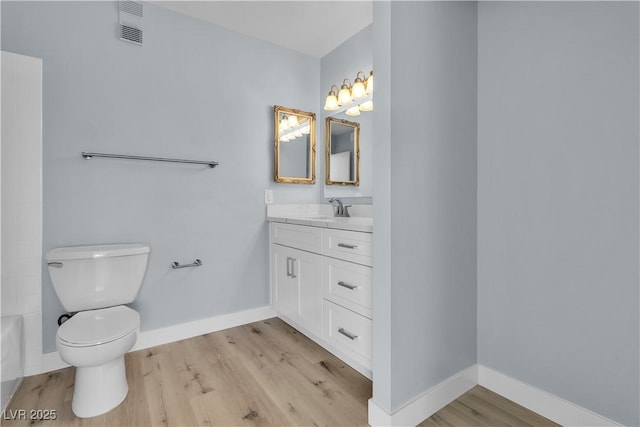 full bathroom featuring visible vents, baseboards, toilet, wood finished floors, and vanity