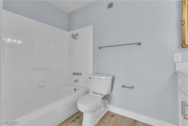 bathroom with visible vents, baseboards, toilet, shower / bathing tub combination, and wood finished floors