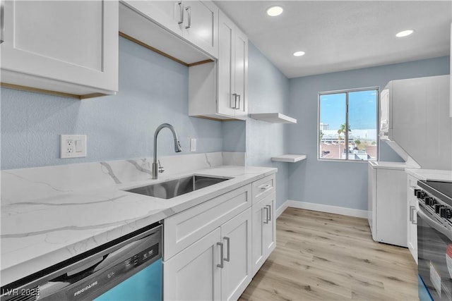 kitchen with light wood-type flooring, a sink, open shelves, white cabinetry, and dishwashing machine