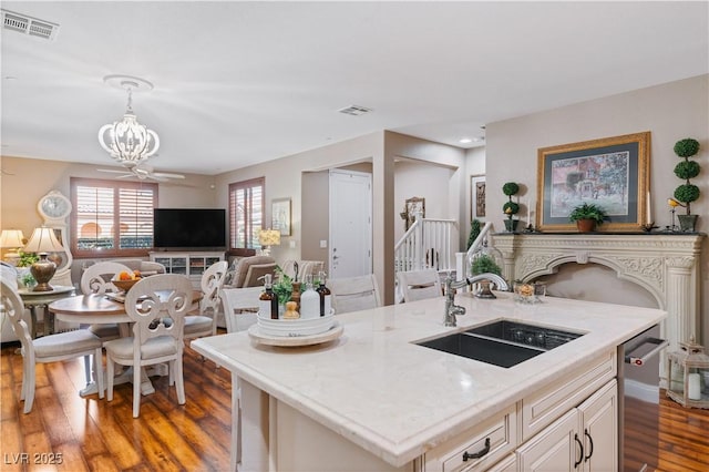 kitchen with visible vents, pendant lighting, a sink, open floor plan, and wood finished floors