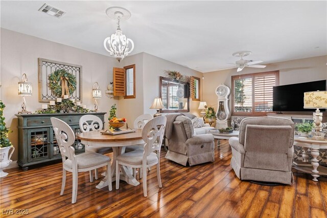 interior space with hardwood / wood-style flooring, ceiling fan with notable chandelier, and visible vents