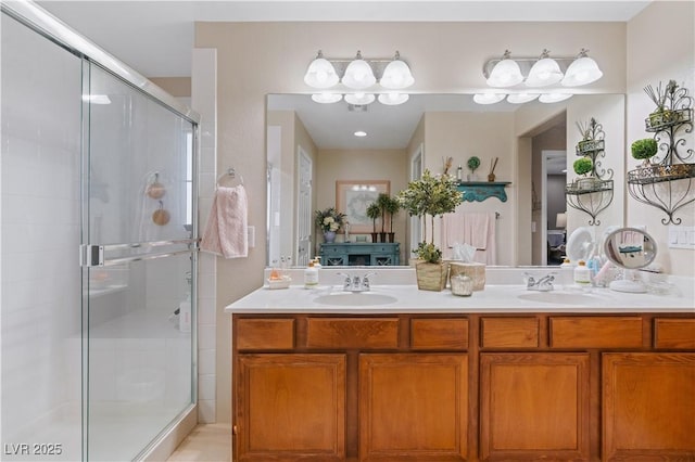 ensuite bathroom with double vanity, connected bathroom, a stall shower, and a sink