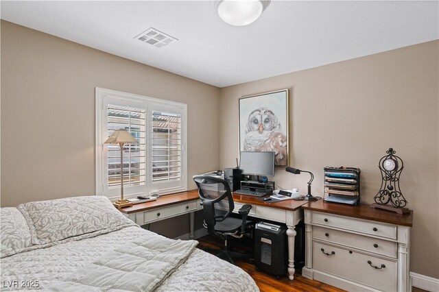 bedroom with dark wood-style floors and visible vents