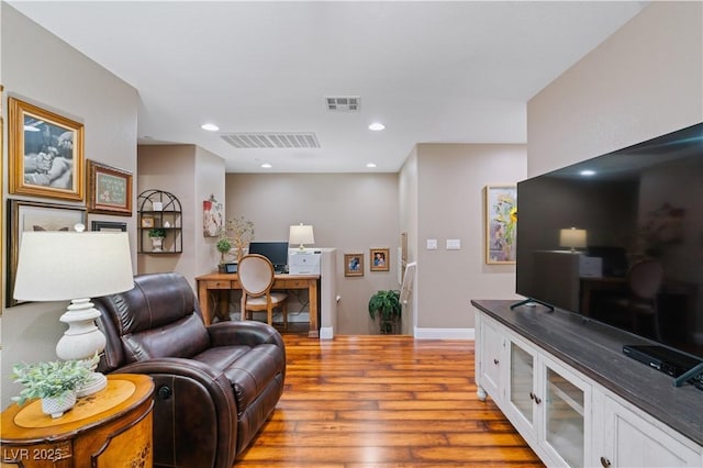 living area with recessed lighting, wood finished floors, visible vents, and baseboards