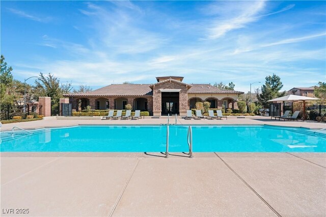 community pool featuring a patio and fence