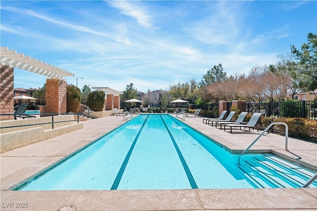 community pool with a patio and fence