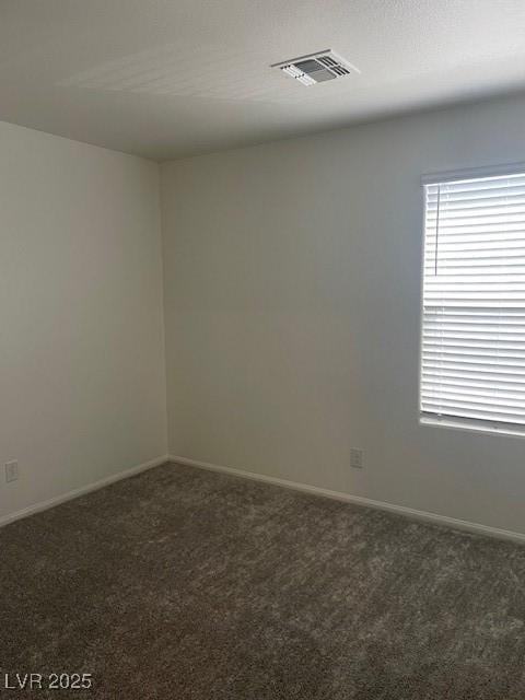 carpeted spare room featuring baseboards and visible vents