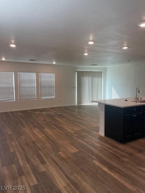 spare room with recessed lighting, dark wood-style flooring, and a sink