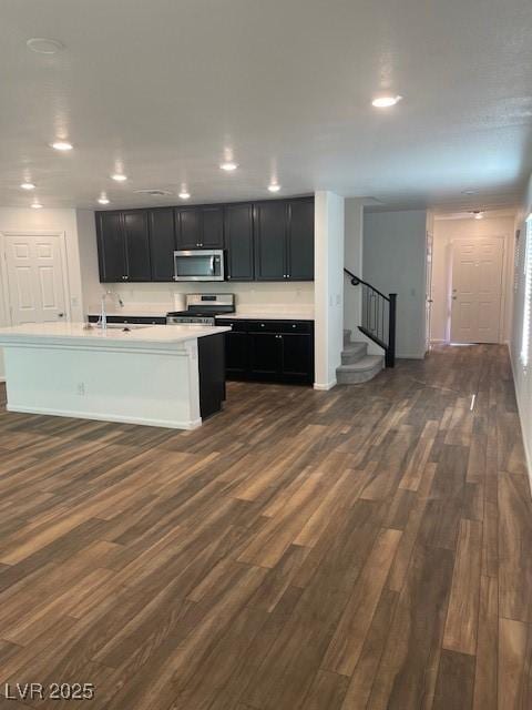 kitchen with dark wood finished floors, light countertops, recessed lighting, appliances with stainless steel finishes, and dark cabinetry