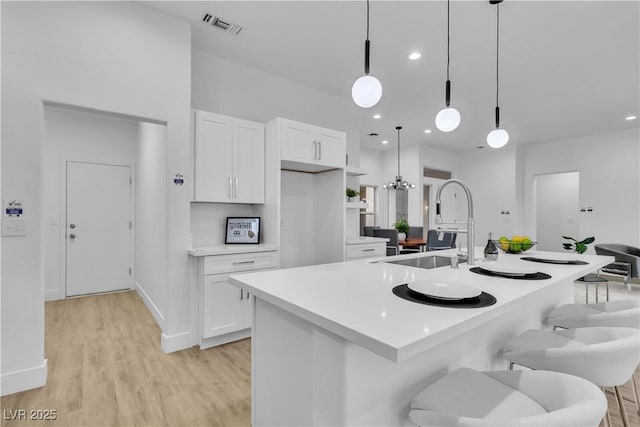 kitchen featuring visible vents, light wood-style flooring, white cabinetry, and light countertops