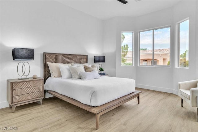 bedroom featuring light wood-style floors and baseboards