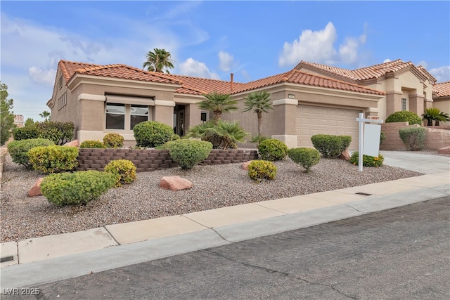 mediterranean / spanish house with a tiled roof, a garage, driveway, and stucco siding