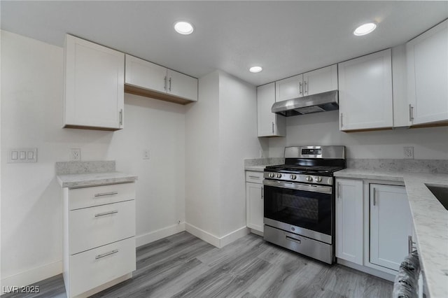 kitchen with stainless steel gas stove, light wood-style flooring, under cabinet range hood, white cabinetry, and recessed lighting