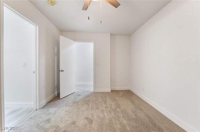 unfurnished room featuring baseboards, light carpet, and a ceiling fan